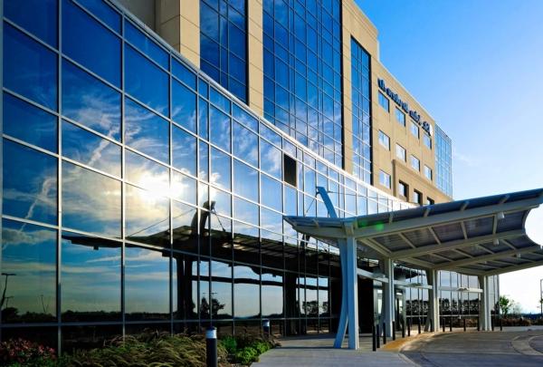 Exterior photo of St. Johns Broken Arrow Medical Campus. Sun reflecting off the six-story glass building.