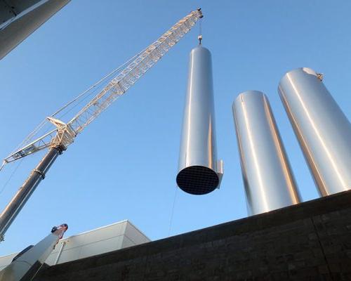 胡德乳业工厂的施工起重机正在安放不锈钢容器.
