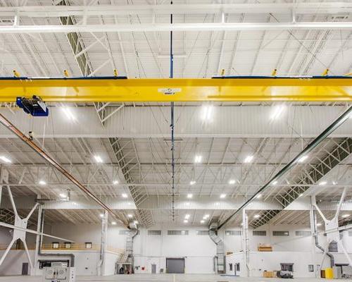 汉莎航空技术公司重型维修设施内部. 宽敞的开放空间，白色的墙壁，明亮的灯光和黄色的天花板梁.