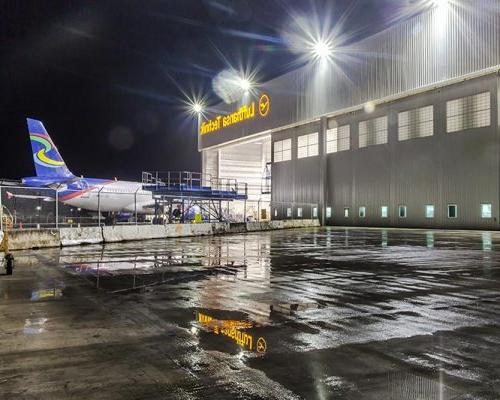 汉莎航空技术公司重型维修设施外的夜晚. 飞机从后面进入机库.