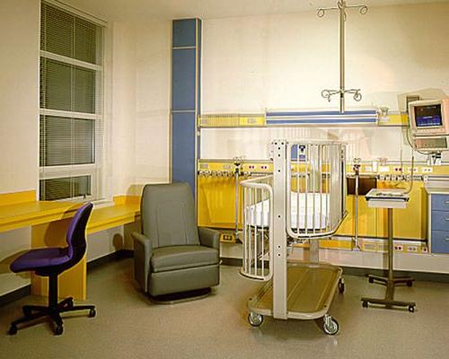 病房内部照片. 婴儿床和椅子放在房间的中央.